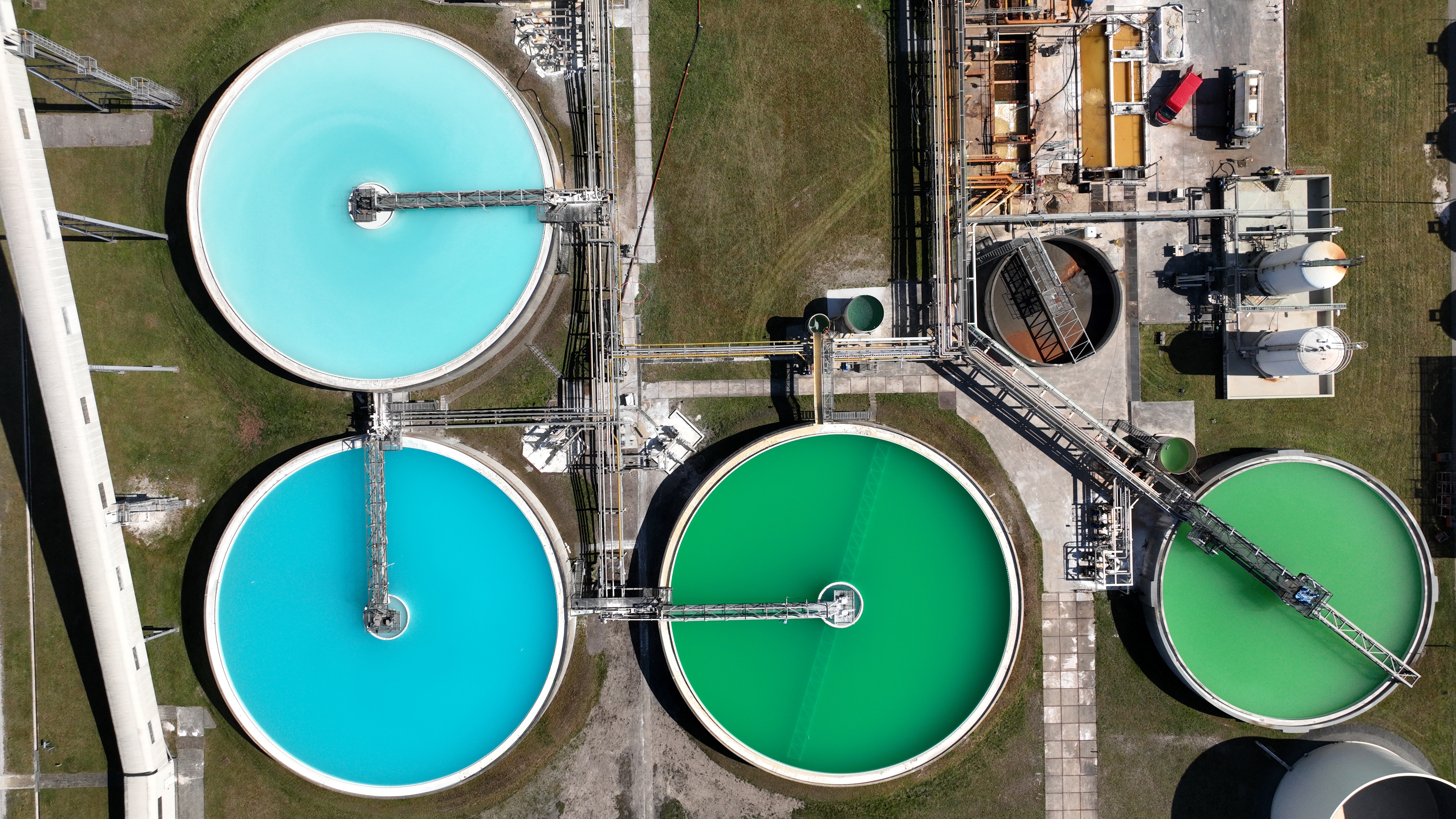 Aerial view of industrial facility with circular basins, water treatment plant, professional drone photography
