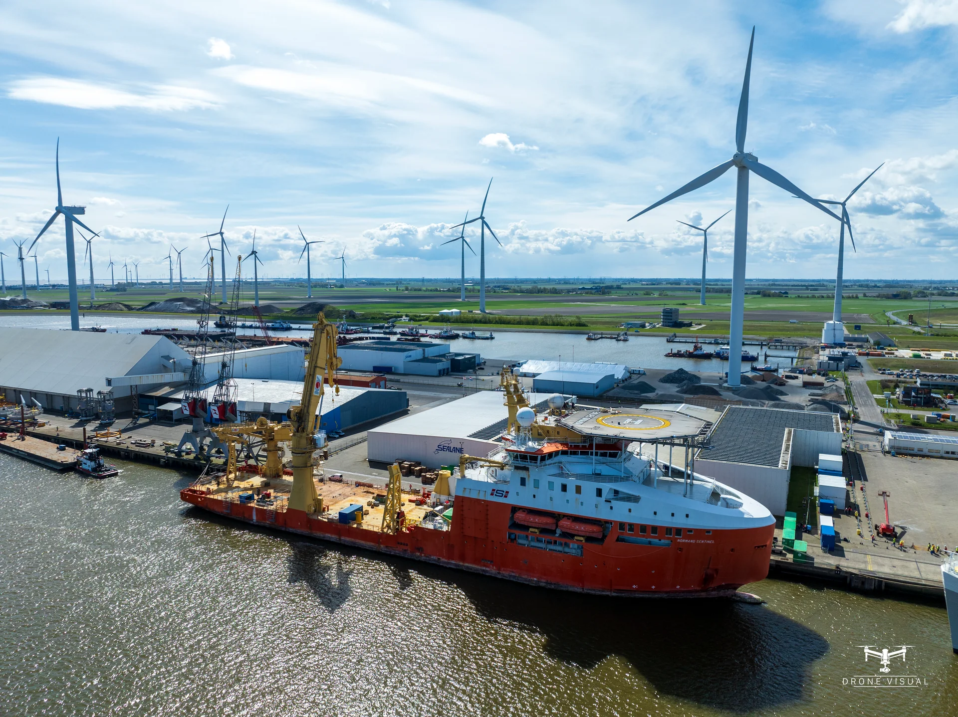 cinematic aerial video production of wind farm at sunset, professional drone filming, renewable energy marketing content, dramatic lighting