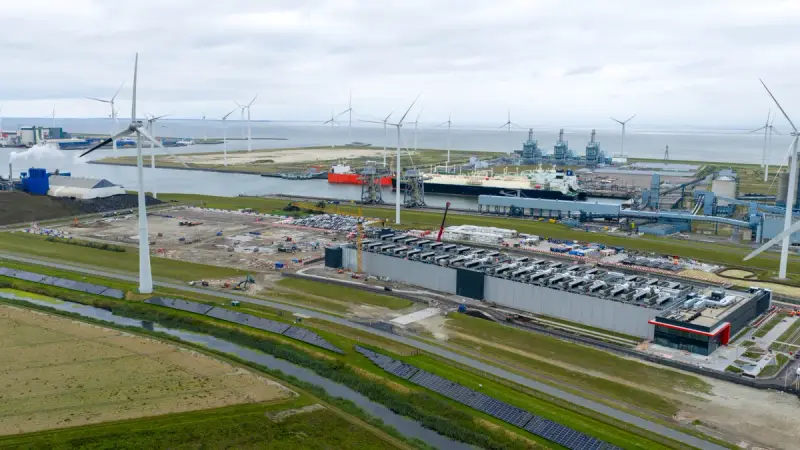 Datacenter in aanbouw met windturbines, zonnepanelen en een haven