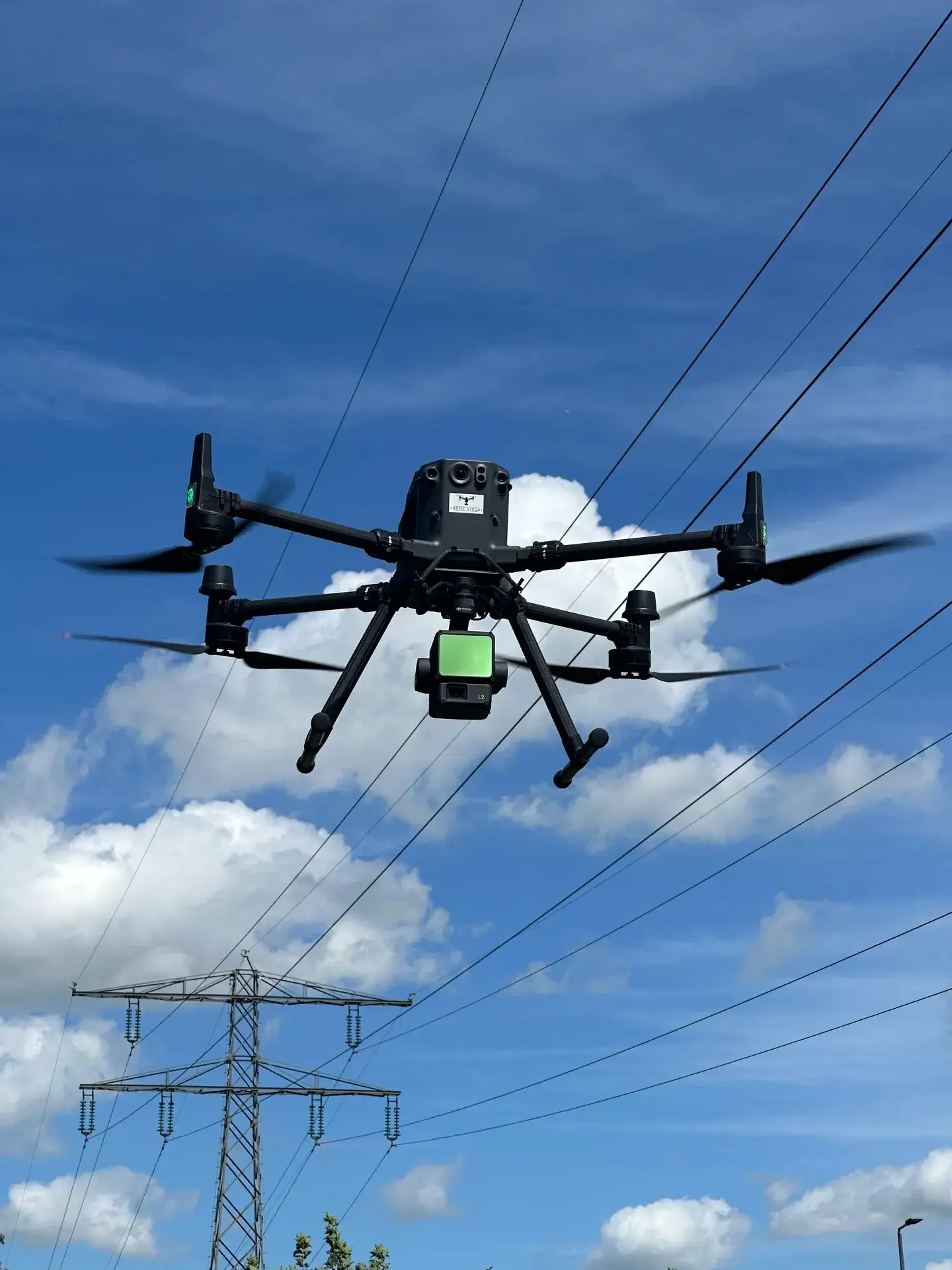 DJI Matrice 350 RTK met Zenmuse L2 van Drone Visual, in de lucht bij hoogspanningskabels