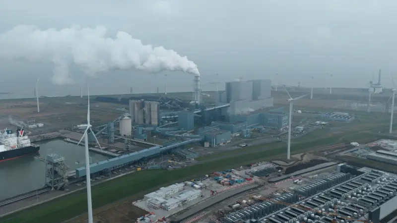 Energiecentrale met rookpluim, windturbines en de zeehaven in de Eemshaven