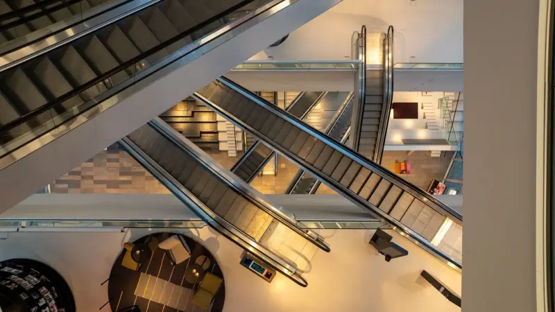 Kruisende roltrappen in een groot atrium, van bovenaf gefilmd