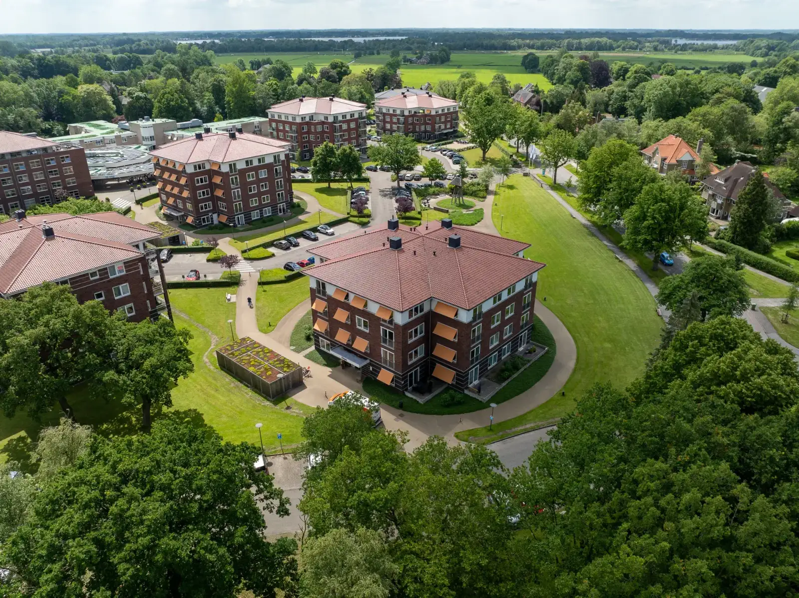 Appartementengebouwen met rode pannendaken en oranje zonneschermen, van bovenaf