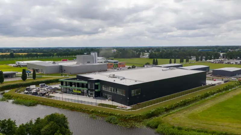 Nieuw zwart bedrijfsgebouw van Q-Farms aan het water