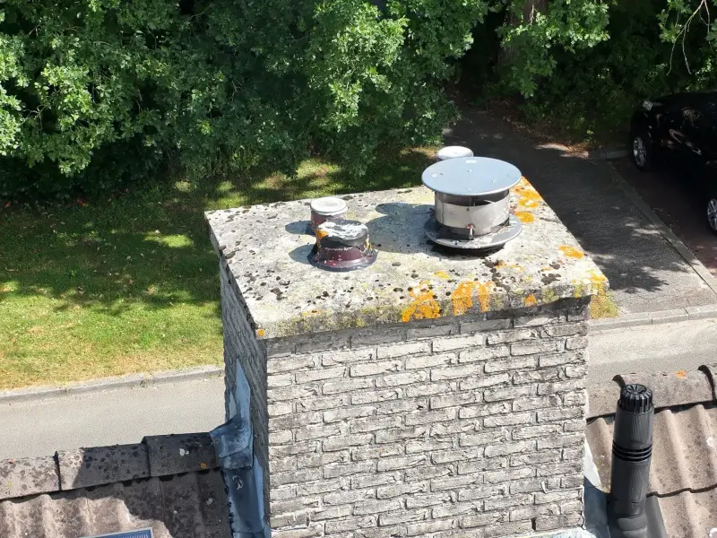 Bakstenen schoorsteen met ventilatiekappen en korstmos, van bovenaf gefotografeerd