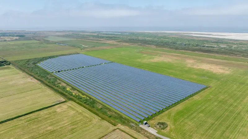 Groot zonnepark tussen weilanden, vanuit de lucht gefotografeerd